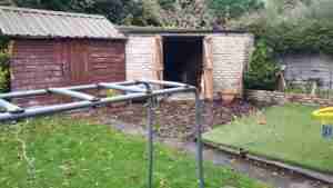 Image of old decking, artificial lawn and sheds.
